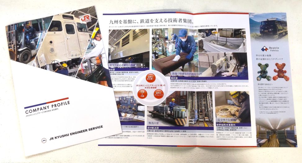 JR九州ES_会社案内パンフレット_サムネイル…表紙を見せたパンフレットと、開いて中面を見せたパンフレットが並んでいる。