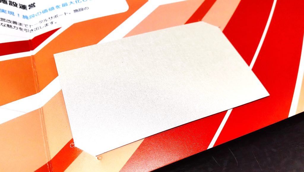 九電ビジネスフロント様_営業ツール_名刺をはさめる切り込み加工を施した部分のアップ　名刺の右上と左下部分の角を1cm程度の切り込みに差し込んで固定する。